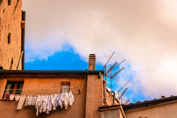 Facade of a typical Italian house in the famous city of Volterra in Tuscany with clothes hanging to dry.