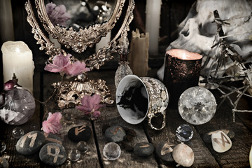 Close up of mystic objects, skull and pink flowers. Divination rite