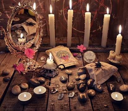 Mystic ritual with burning candles, magic mirror, flowers and the tarot cards. Divination rite