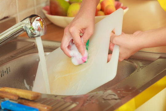 Woman Doing The Washing Up In Kitchen