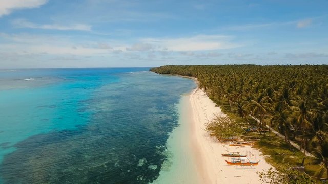 Aerial view of beautiful tropical island Daco with white sand beach. View of a nice tropical beach from the air. Beautiful sky, sea, resort. Seascape: Ocean and beautiful beach paradise. Philippines