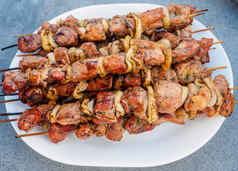 Shish kebabs on skeweres cooked on charcoal gril laid out on a platel