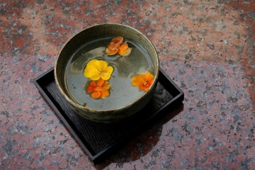 bowl with colorful flower petals floating on surface of water
