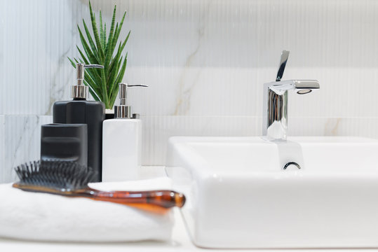 Modern faucet with hand towel, comb and dispenser bathroom interior