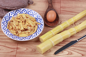 Fried soft bamboo pole shoots with egg and kitchen equipment cooking.