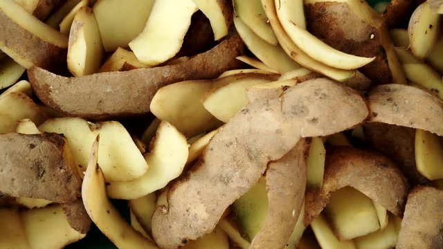 Heap of potato peels as background. Peeling old potatoes. Dolly slider shot 4K ProRes HQ codec