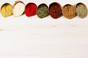 Varied powder spices close-up on  white wooden board with  copy space.