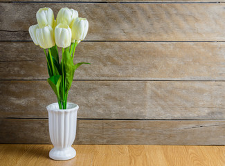 white tulip flowers bouquet in vase on wooden floor