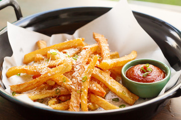 French fries in a bowl on a wooden background