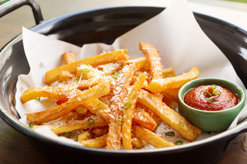 French fries in a bowl on a wooden background
