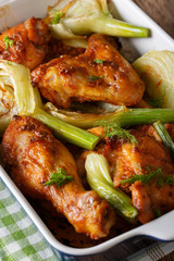spicy chicken baked with fennel in a baking dish close-up. vertical
