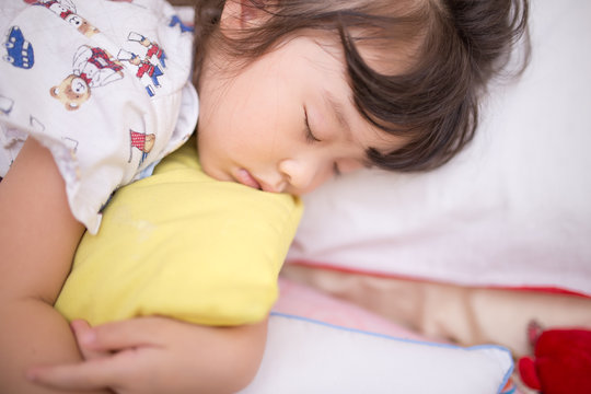 asian little girl sleeping on the bed