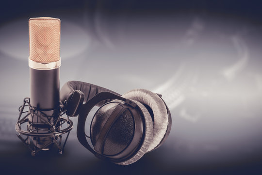 Headphones and condenser microphone on the dark background