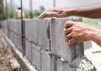 bricklayer installing bricks Masonry work in construction site