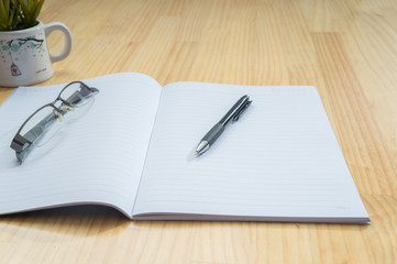 Notebook and pen on wooden desk