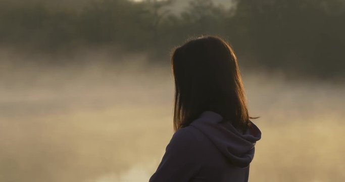Silhouette of a woman on a background of fog