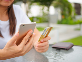 Online payment, women's hands holding a credit card and using smart phone for online shopping