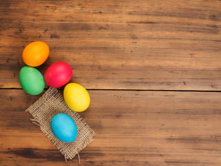 Easter eggs on old brown wood and burlap background. Top view, horizontal. Mock up for your greetings card or poster. Russian and Ukrainian, orthodox, slavic traditional Easter, rural background.