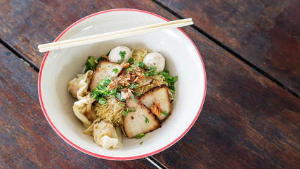 Noodles with pork on a wooden background (Thai noodles).
