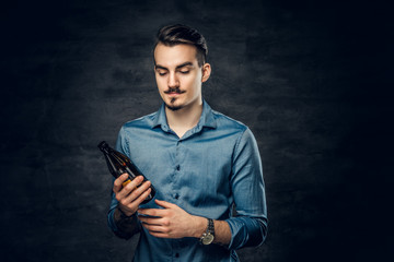 A man holds craft bottled beer.