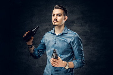 A man drinks craft bottled beer.
