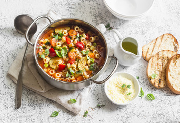 Vegetarian minestrone - delicious healthy mediterranean lunch. On a light table, flat lay - obrazy, fototapety, plakaty