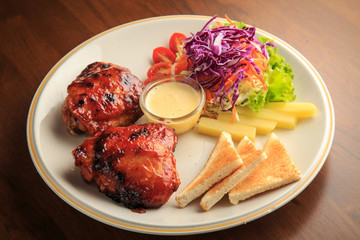 Chickens fried steak with vegetables salad on white dish and wooden background
