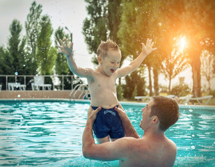 Father and son funny in water pool under sun light at summer da