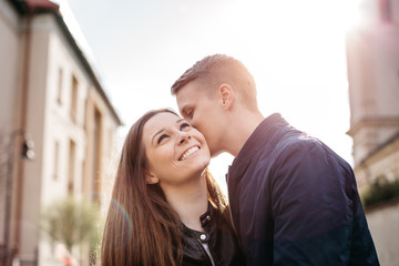 A boyfriend whispering into his girlfriends ear while dating in the city