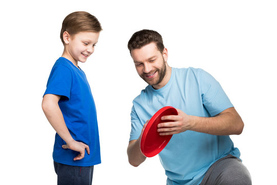 Father and son playing together with frisbee isolated on white