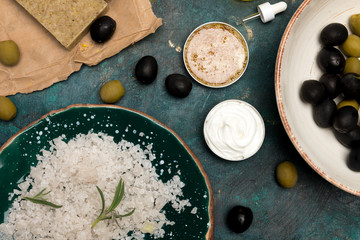 Top view of handmade soap, sea salt and olives for homemade cosmetics