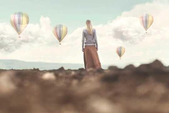 Dreamy woman looks at the hot air balloons coming down