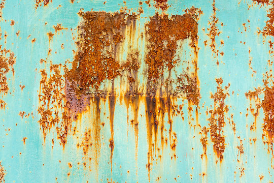 Close up of rusty flaking steel plate with light blue color.