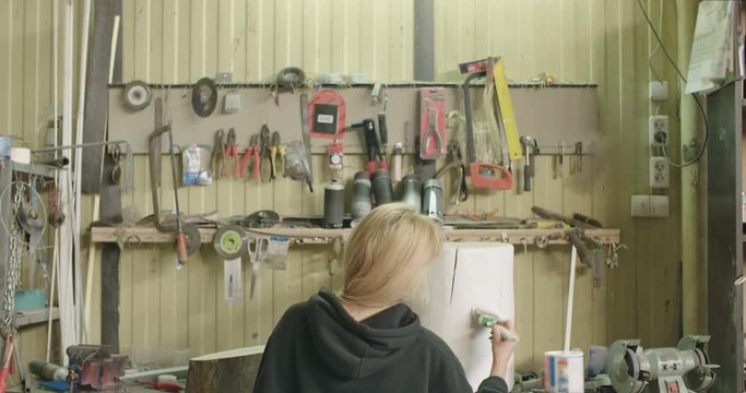Woman Painting Tree Stump In Workshop