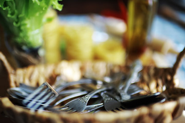 A lot of forks in a wooden basket