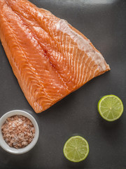 raw salmon fillets on dark background