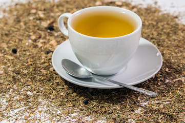 Cup of Tea. A hot white cup of tea on a saucer with a teaspoon.. A cup of tea on the table