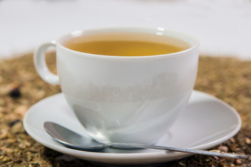 Cup of Tea. A hot white cup of tea on a saucer with a teaspoon.. A cup of tea on the table