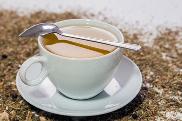 Cup of Tea. A hot white cup of tea on a saucer with a teaspoon.. A cup of tea on the table