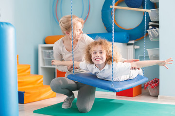 Happy boy lying on swing