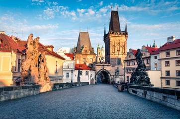 Sunny spring scene on Charles bridge on Vltava river (Karluv Most) with statues and Prague castle