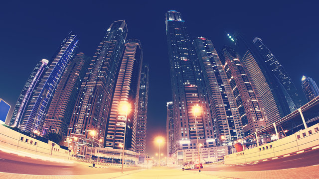Fisheye lens panoramic picture of Dubai city downtown at night, color toning applied, United Arab Emirates.