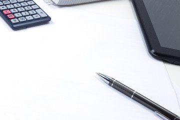 In the office on the table, a report, coffee, a tablet with a pen