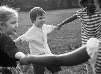 Fototapeta premium Group of kindergarten kids friends holding hands playing at park