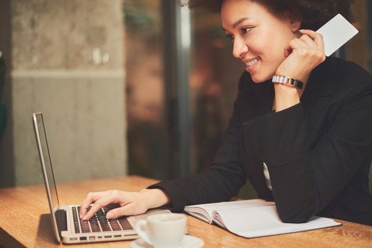 Mixed Race Busy Woman Using Credit Card For Shopping And Paying Bills On Line While Sitting In Coffee Shop