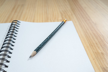 Notebooks and pencils on wooden board