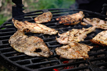 Grilling chicken fillets at a barbecue