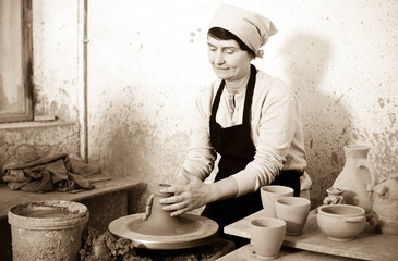 Female elderly master among the pottery