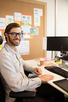 Portrait of smiling designer sitting at creative office