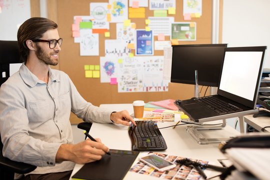 Businessman working on digitizer at creative office desk